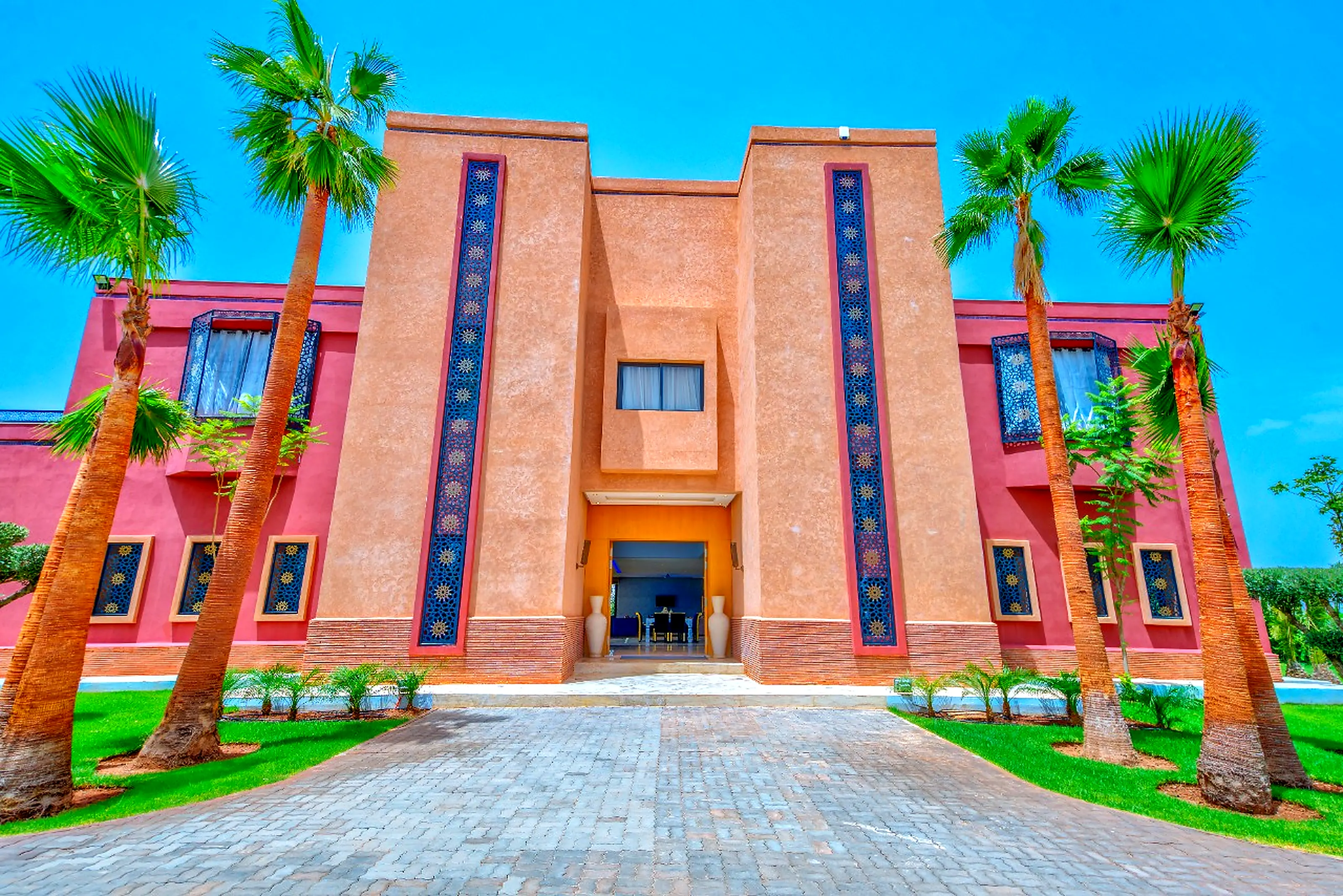 Main facade golden hour - Warm light on terracotta, palm shadows, ultra luxury